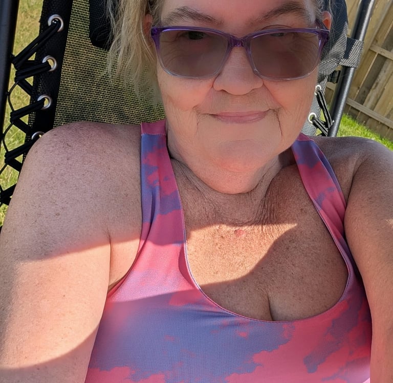 woman lounging in the sun, in her backyard