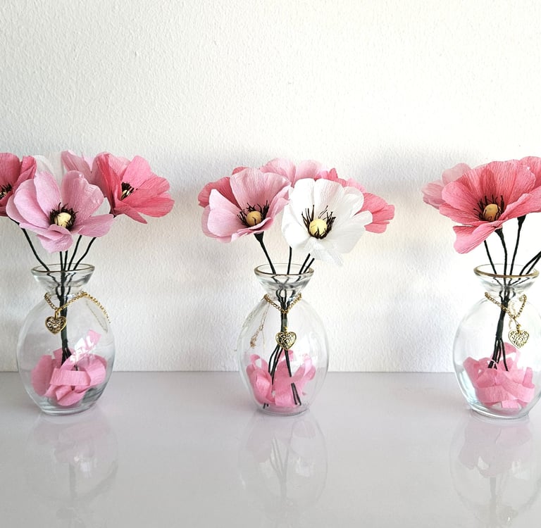 Vaasjes met roze en witte bloemen van crêpepapier