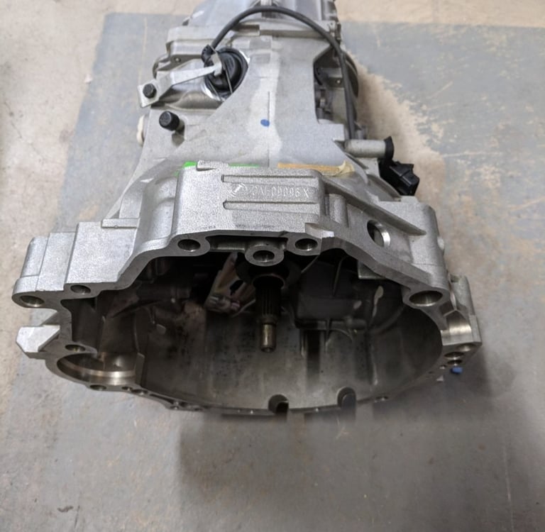 Used manual car transmission assembly for vehicle repair and replacement parts.