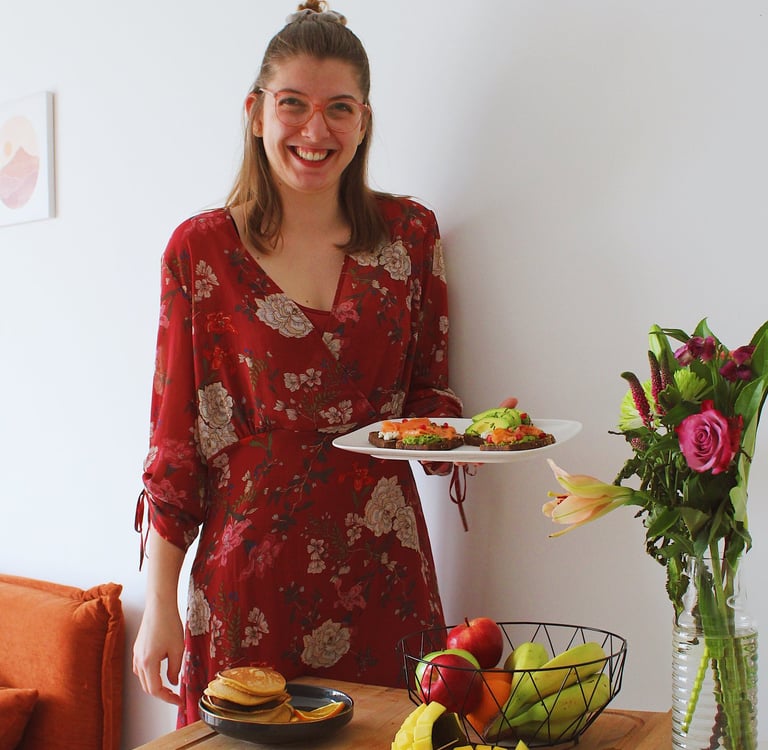 Amélie Biron, souriante, présentant un brunch appétissant, plein de couleurs et de saveurs. 