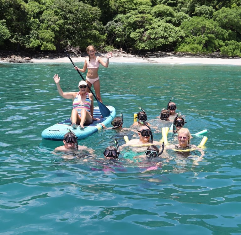 Family enjoying snorkeling and paddle boards in turquoise waters during catamaran tour Papagayo