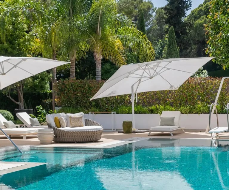 Poolside daybeds with umbrellas at Villa Serenity gardens