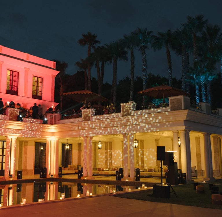 Grand villa façade illuminated in red at night
