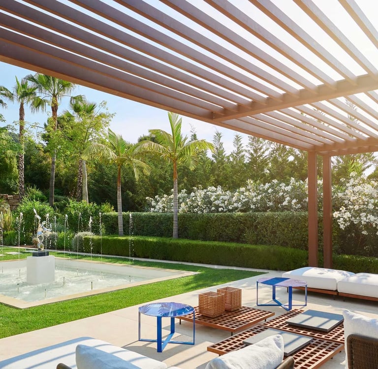 Shaded outdoor seating area overlooking a sculptural water fountain