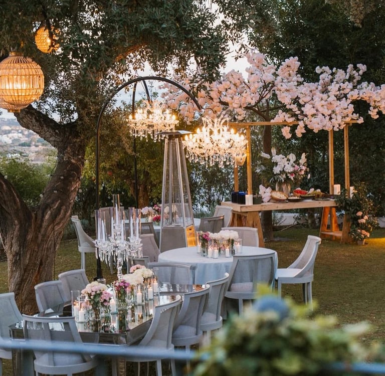 Garden dinner setting under trees with ambient lighting