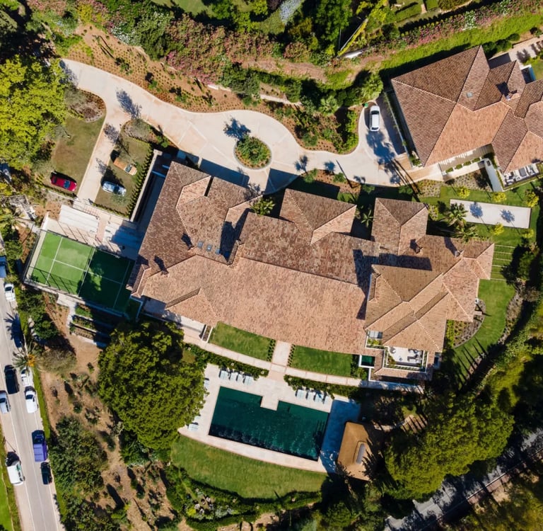 Aerial view of estate with pool, tennis court and landscaped gardens