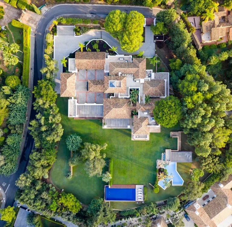 Aerial view of hillside estate with expansive gardens