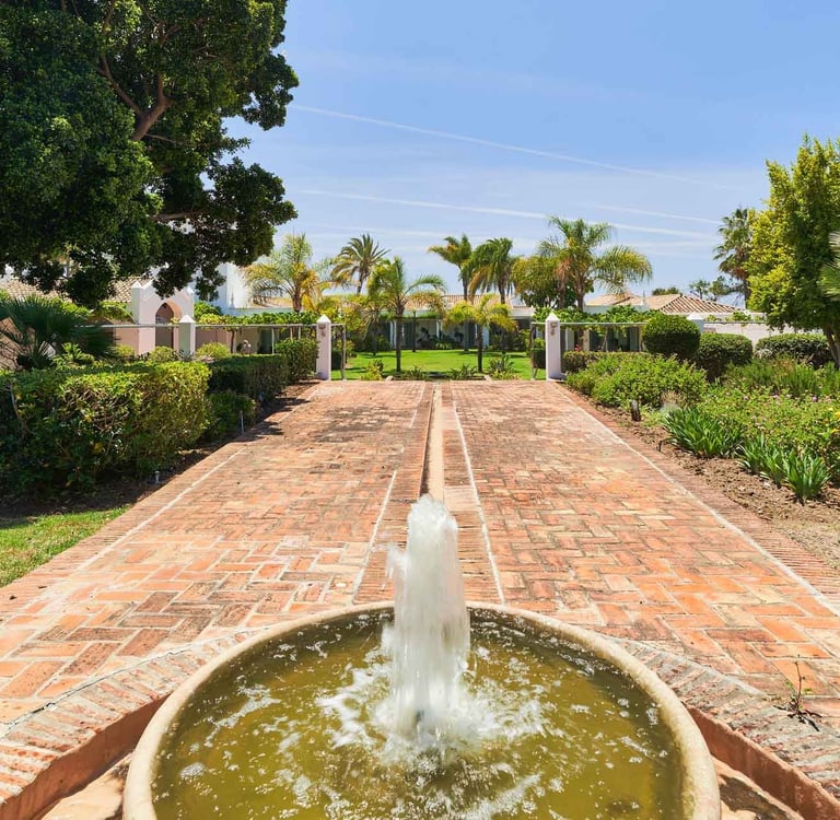 Brick pathway with fountain leading to beachfront villa