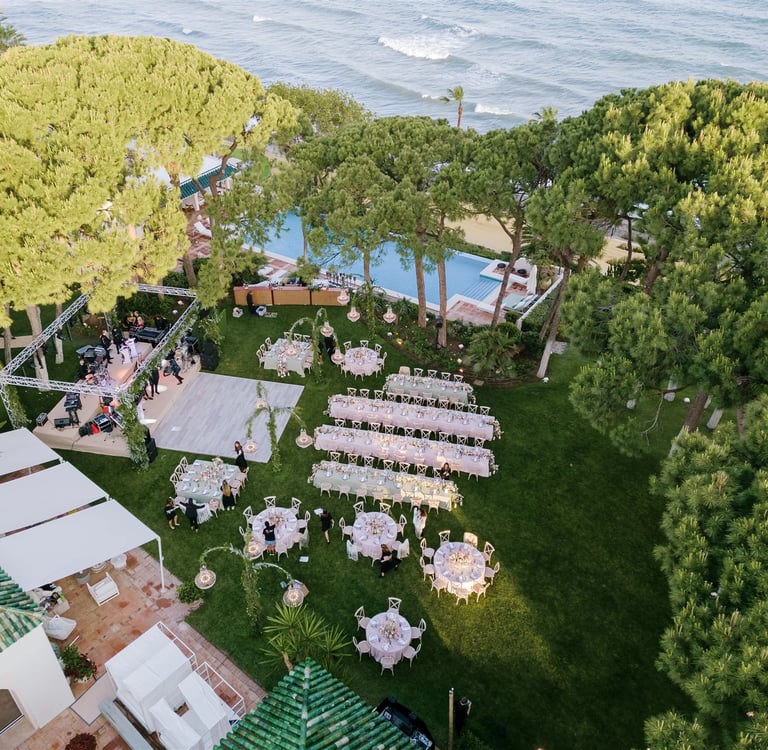 Aerial view of beachfront wedding layout under pine trees