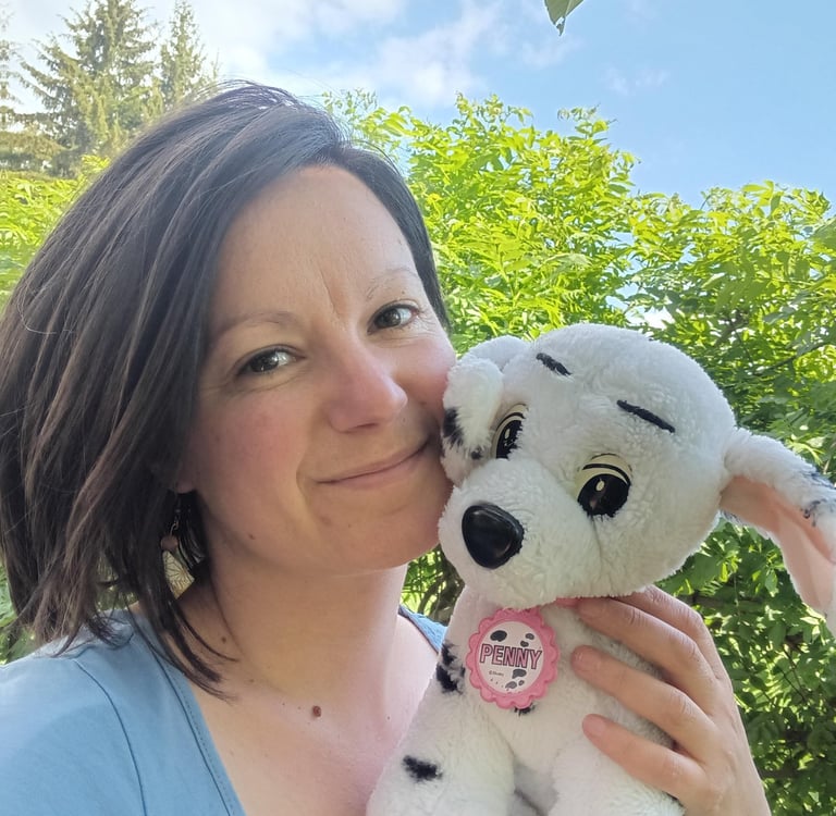 Natacha Rossignol tenant sa peluche d’enfance Penny dans un jardin ensoleillé des Hautes-Alpes