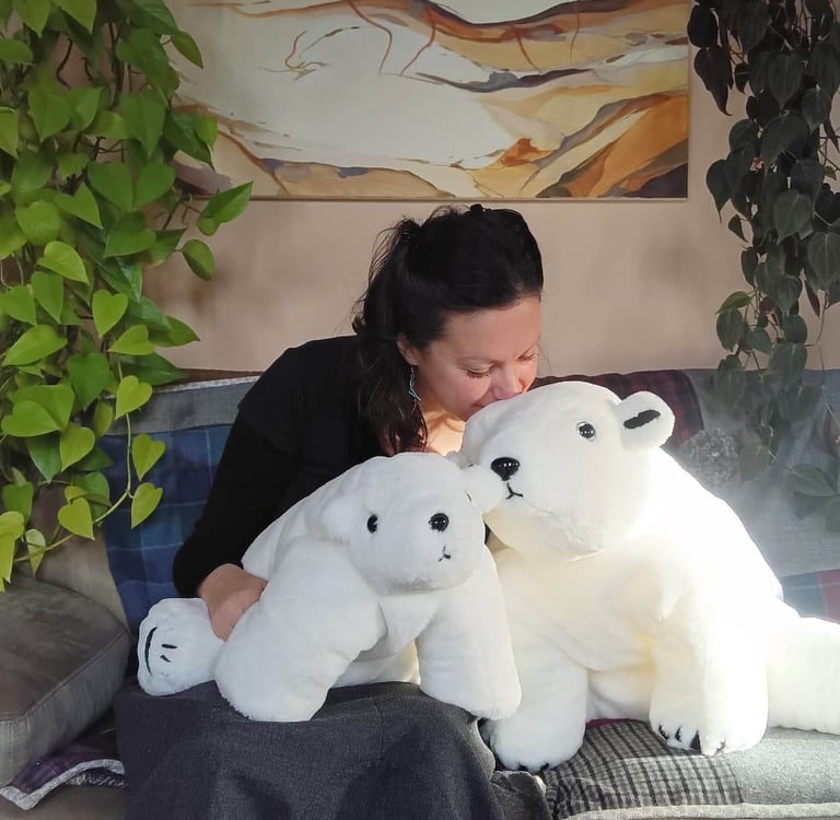 Créatrice de peluches artisanales tenant deux ours polaires en tissu cousus main, compagnons de douc