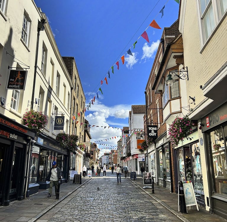 Rue pietonne pavée bordée de petits magasins 