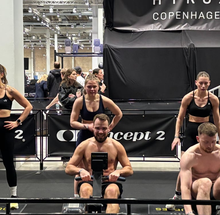 Arena shot – bright lights, crowds, athletes rowing