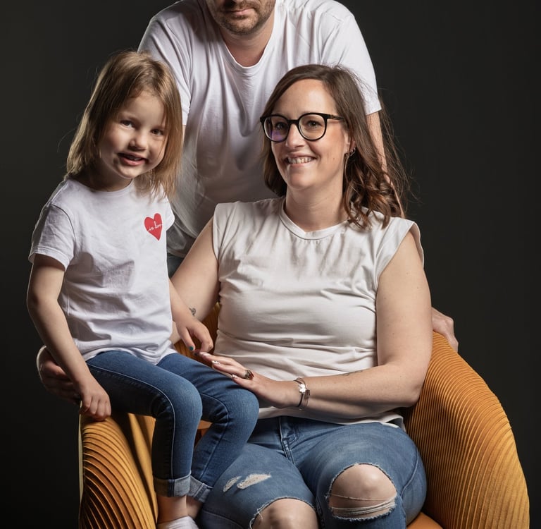 Couple avec un enfant, fauteuil jaune et fond noir