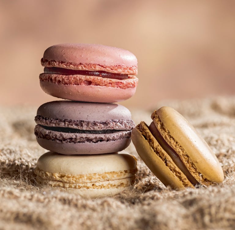 4 macarons dont trois empilés sur toile de jute et fond marron clair
