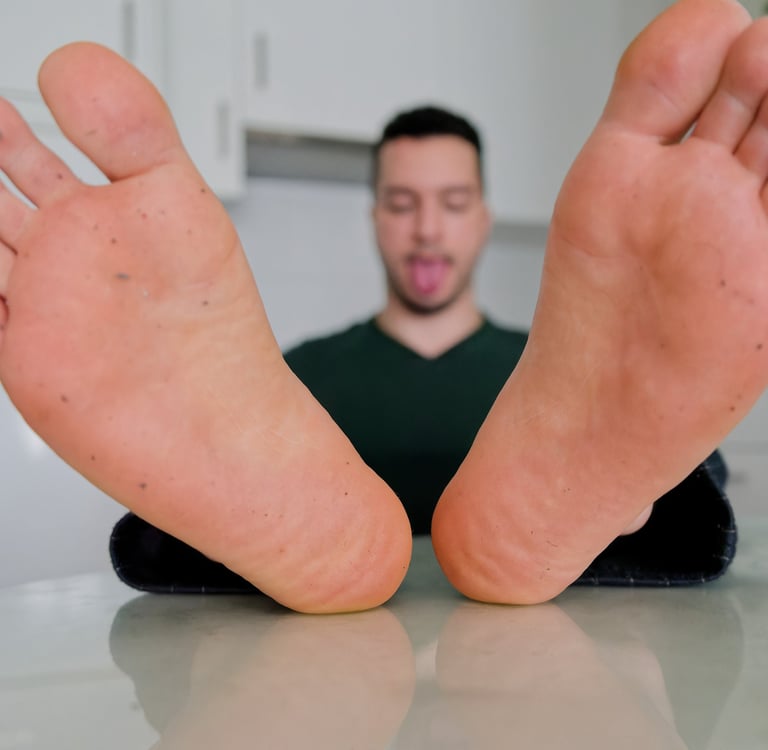 a man with his tongue out and showing dirty feet