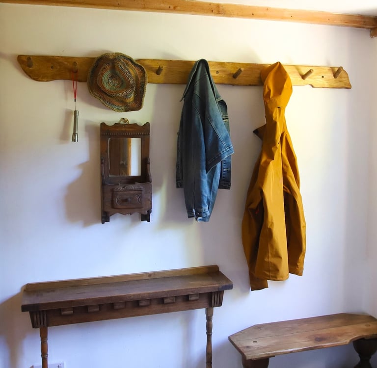 Holiday rental coat rack with jackets, a hat and a pair of boots