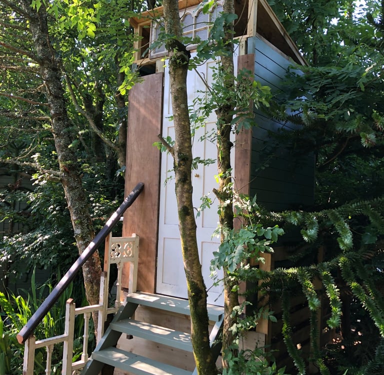 steps up to a wooden building housing a compost toilet