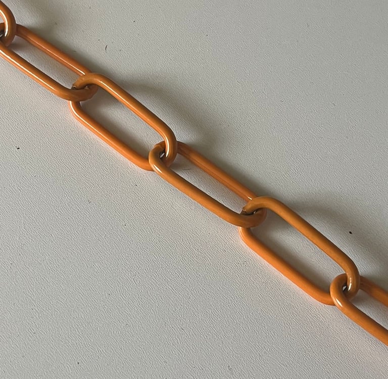 Runder Kreis mit einem Farbmuster mittig eine Kette in Orange, Hundekette, Pulverbeschichtet