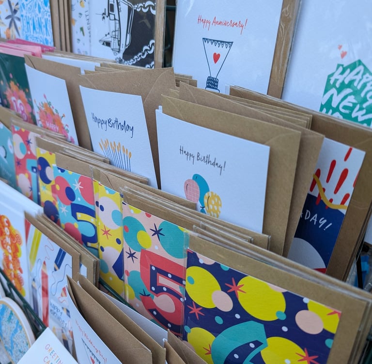 A collection of Inky Acorn Designs' colourful greetings cards on display