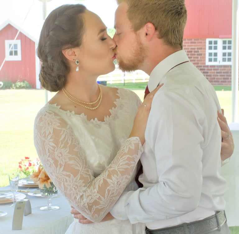 a bride and groom kissing in a tent
