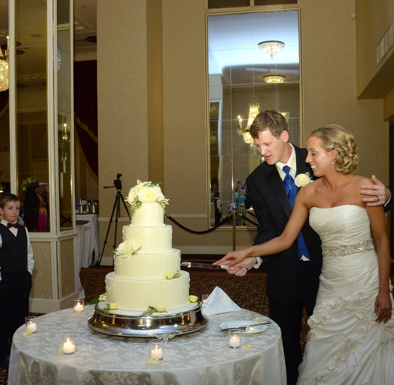 a bride and groom cutting their wedding cake in a hotel