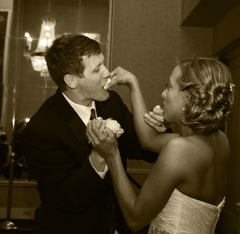 a bride and groom feeding each other a piece of cake