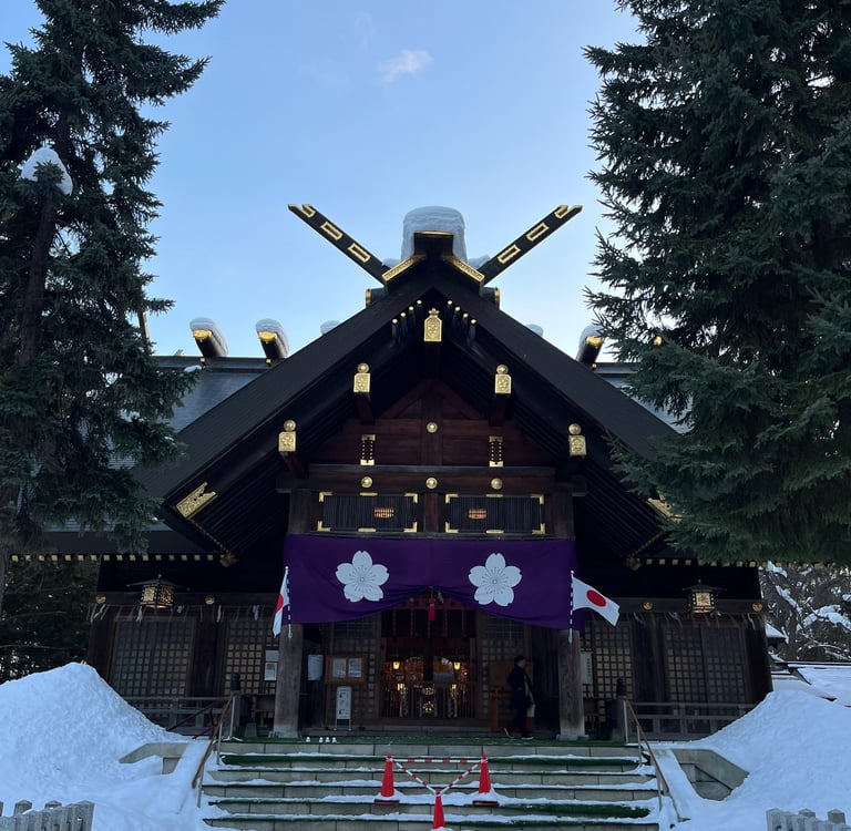 a large wooden building like a temple or sanctuary with a large purple banner in hokkaido japan