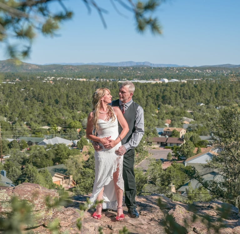 a man and woman standing on a mountain top