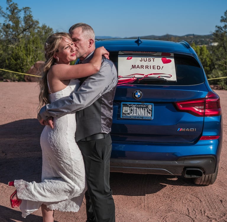 a man and woman standing in front of a car