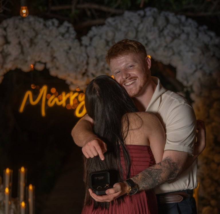 a man and woman embracing in front of a neon sign