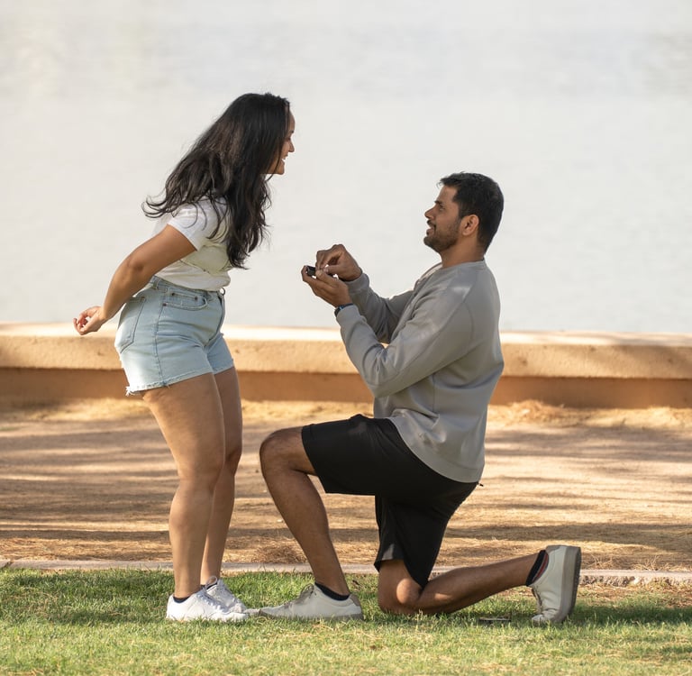 a man proposing a woman in shorts and a white shirt