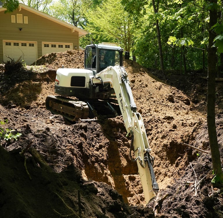 bobcat excavator digging dirt on central mn property