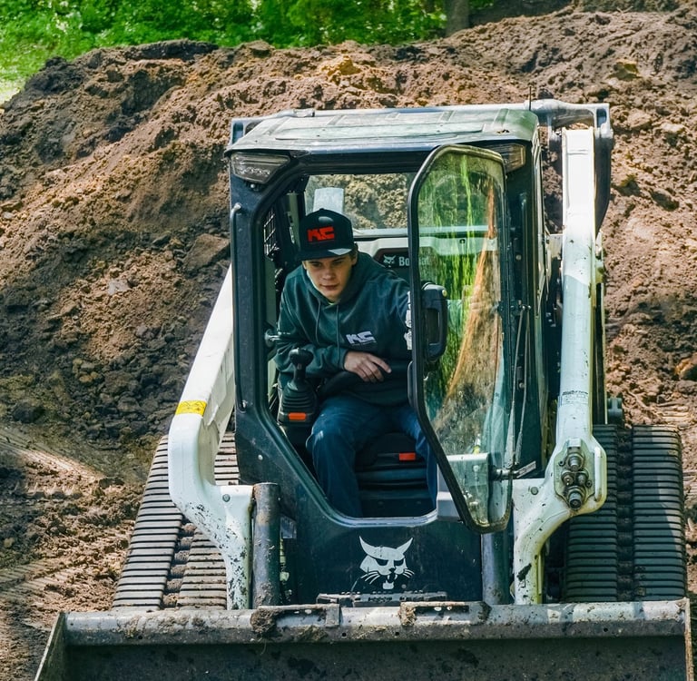Kruse Contracting employee operating a bobcat skid steer