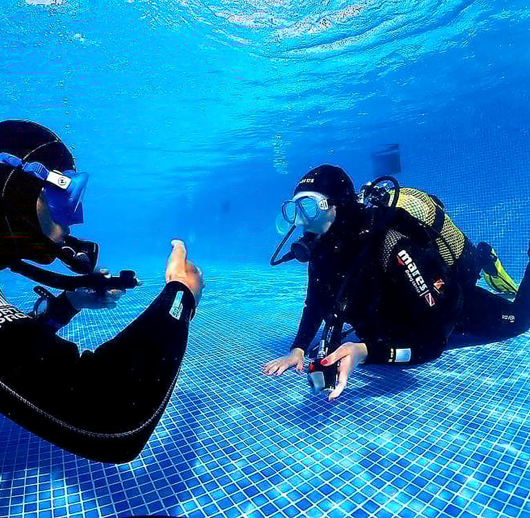 Scuba diving instructor teaching a beginner underwater during a try dive in Funchal, Madeira