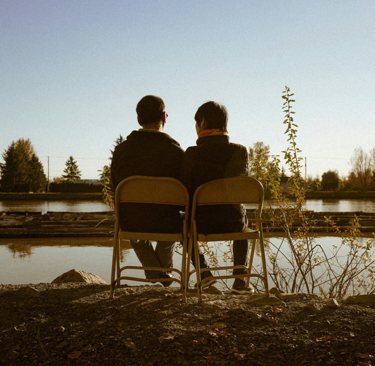 Male couple looking out at a lake concerned about their couples relationship