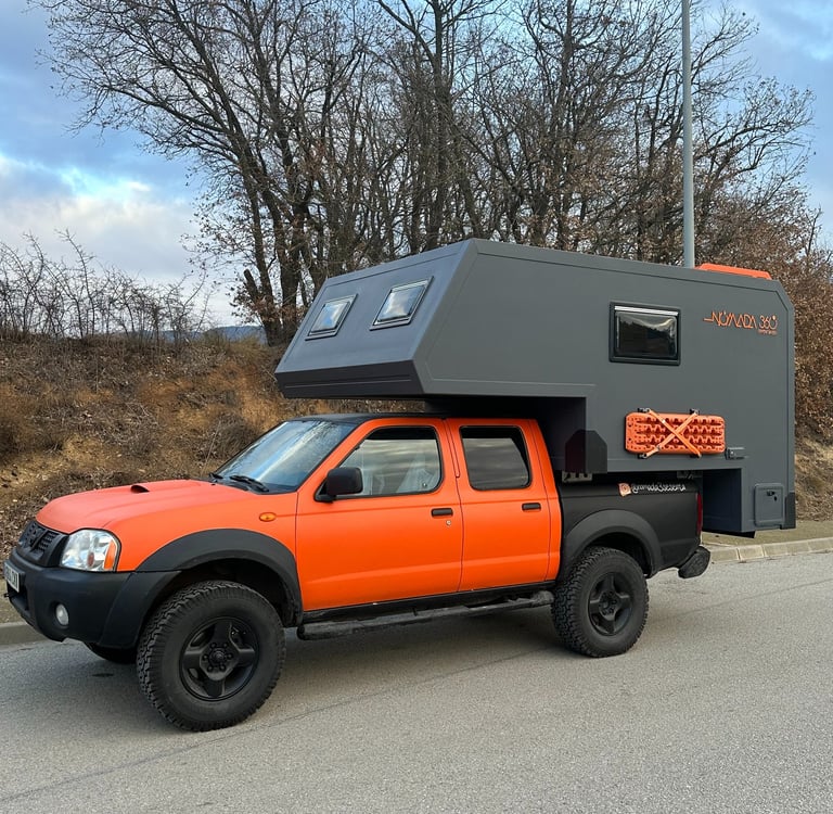 vehículo pick up de color naranja con cabina vivienda