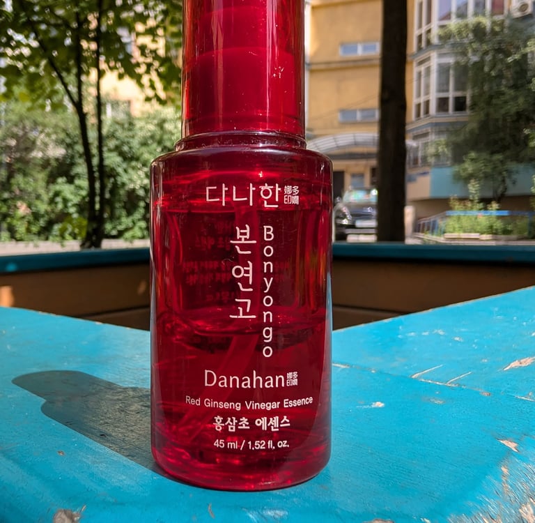 Danahan Bonyongo Red Ginseng Vinegar Essence in a red bottle on a blue wooden surface.