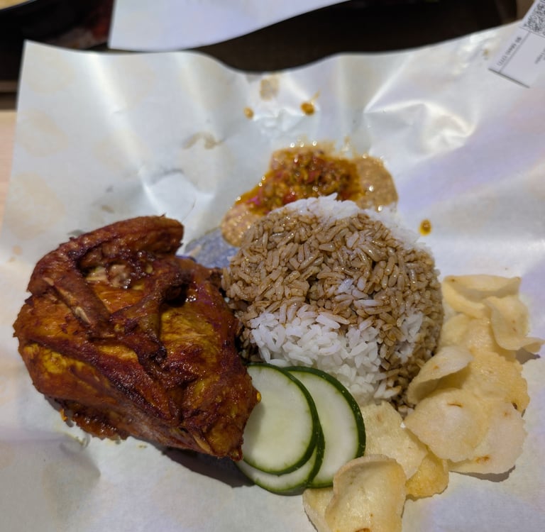 Malaysian Ayam Goreng fried chicken served with steamed rice, spicy sambal, and prawn crackers.