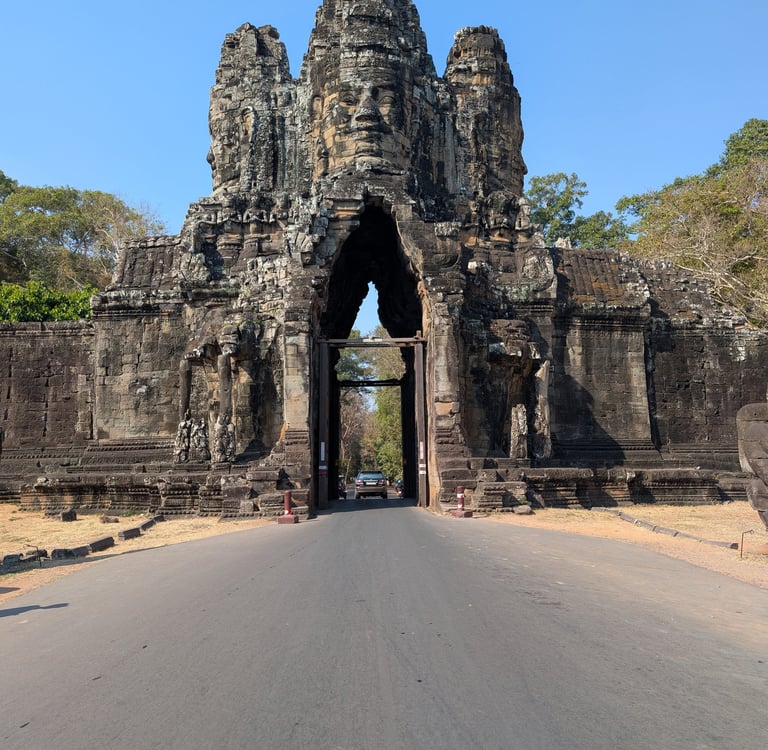 a road passing through a stone gate at Angkor Wat, Cambodia