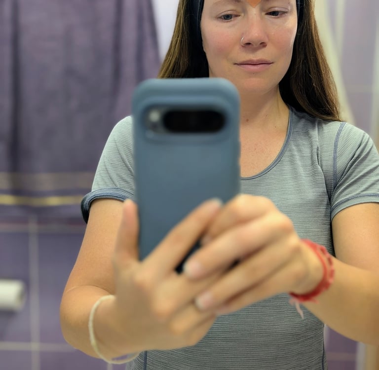Samantha taking a mirror selfie using Frownies forehead wrinkle patches for anti-aging skincare.