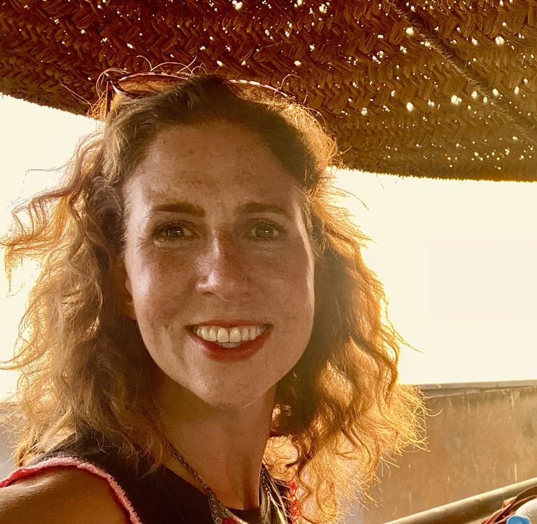 Kat Kojic, a smiling woman with shoulder length curly hair