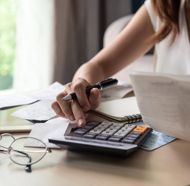 a woman is sitting at a desk with a calculator