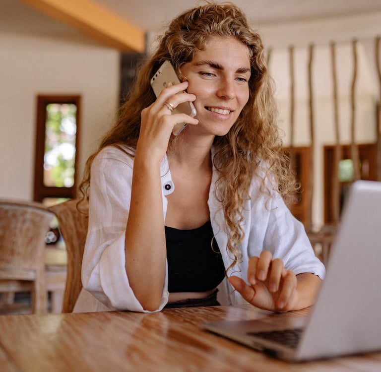 alt="Customer support representative speaking on the phone at a computer"