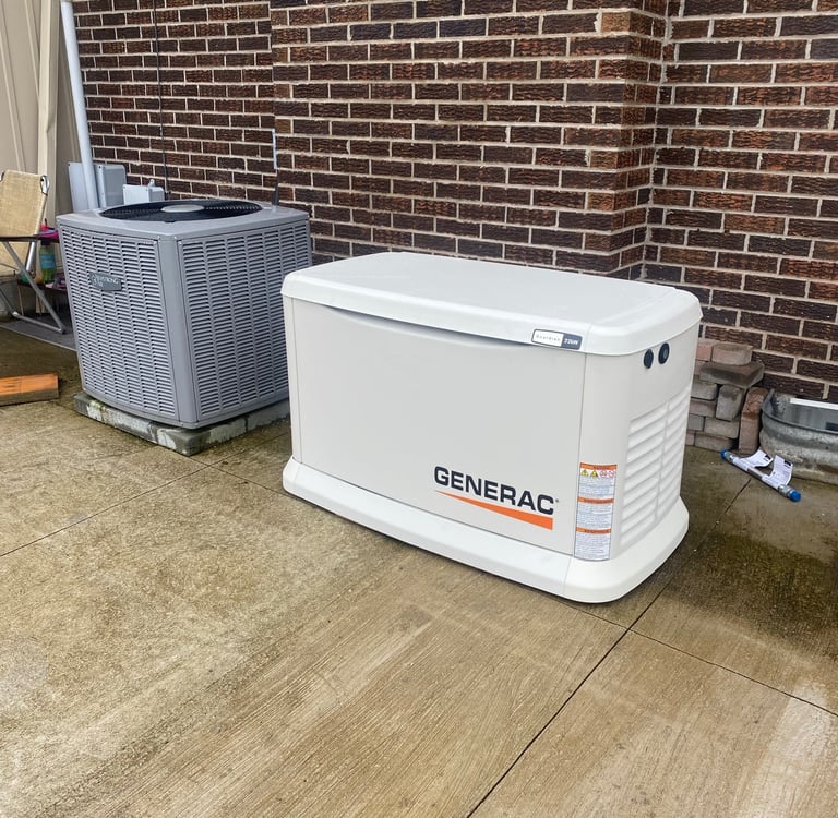 A white Generac home standby generator installed on a concrete pad next to an HVAC unit and brick wall.