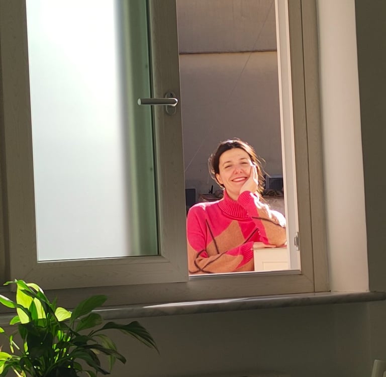 Giusy sorride dalla finestra della nuova casa ad Amalfi, nei primi giorni