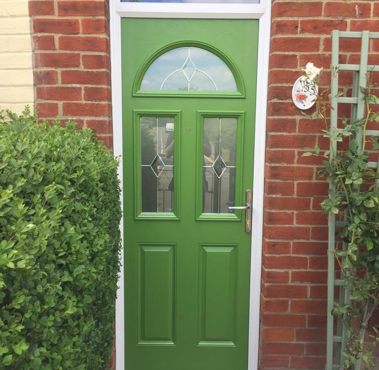 a bespoke bright green front door with diamond lead glass.  there are three windows on the door 