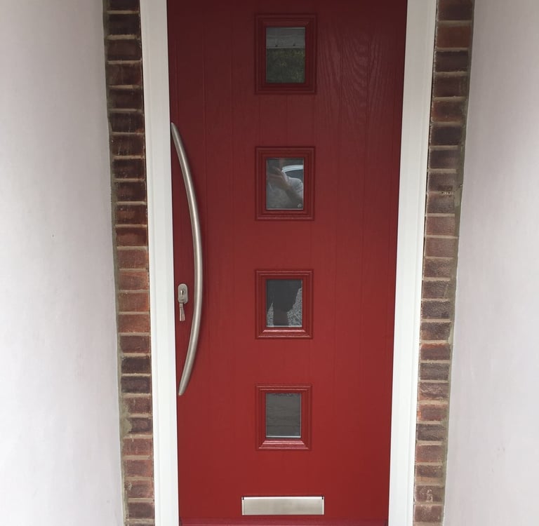 a new red composite front door with 4 squares of glass and curved long handle
