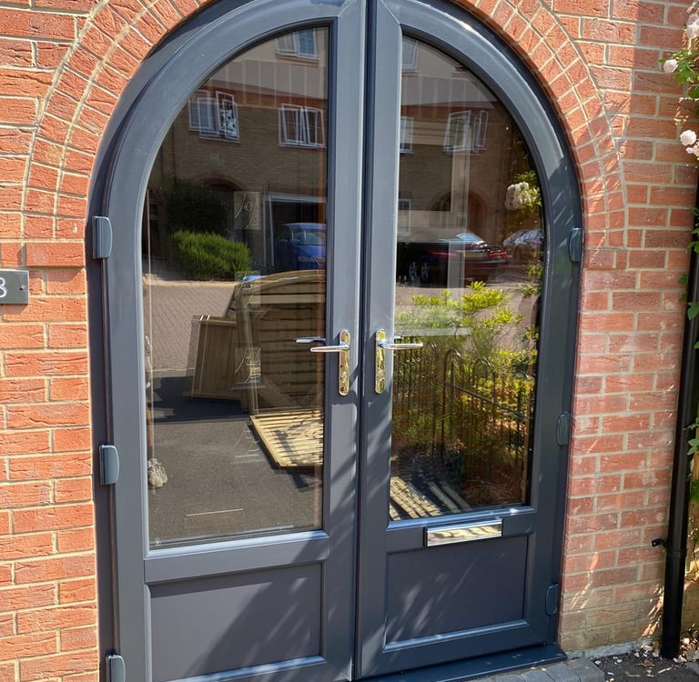 anthracite grey front door with unusual arched shape and reflective glass