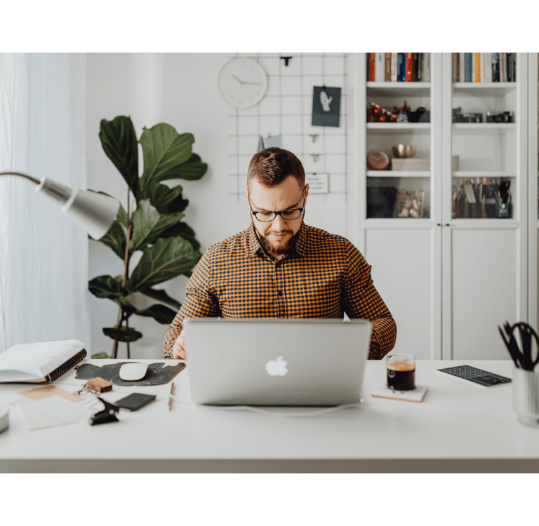 a man sitting at a desk with a laptop computer